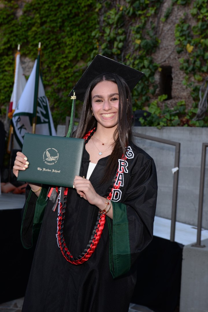 Norah Mehanna in graduation attire holding a Harker School diploma.
